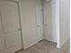 Interior hallway with white doors and tiled floors at 1884 Hickory Bluff Rd, Kissimmee, FL 34744