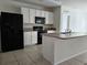 Kitchen with island, black appliances, and white cabinets at 1884 Hickory Bluff Rd, Kissimmee, FL 34744