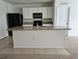 Kitchen with island, black appliances, and white cabinets at 1884 Hickory Bluff Rd, Kissimmee, FL 34744