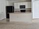 Kitchen with island, black appliances, and white cabinets at 1884 Hickory Bluff Rd, Kissimmee, FL 34744