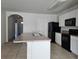 Kitchen with island, black appliances, and white cabinets at 1884 Hickory Bluff Rd, Kissimmee, FL 34744