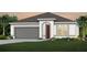 One-story home with gray siding, red door, and two-car garage at 6024 Forest Perch Dr, Saint Cloud, FL 34771