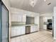 Kitchen with white cabinets, stainless steel appliances, and tile flooring at 11026 Riverside Rd, Leesburg, FL 34788