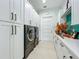 Laundry room with white cabinets, teal backsplash and washer/dryer at 1123 Webster Ave, Orlando, FL 32804