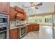 Kitchen with stainless steel appliances, granite countertops, and view into adjoining Gathering room at 12504 Blue Heron Way, Leesburg, FL 34788