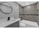 Updated bathroom with grey tile, bathtub, and modern vanity at 3553 Greenfield Ave, Orlando, FL 32808