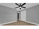 Simple bedroom with wood-look floors, ceiling fan, and double door closet at 3553 Greenfield Ave, Orlando, FL 32808