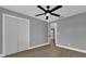 Bright bedroom with wood-look floors, ceiling fan and double door closet at 3553 Greenfield Ave, Orlando, FL 32808