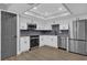 Modern kitchen with white cabinets, stainless steel appliances, and gray backsplash at 3553 Greenfield Ave, Orlando, FL 32808