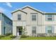 Two-story house with gray siding, blue door, and landscaping at 866 Paradise Dr, Davenport, FL 33897
