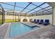 Private screened pool with lounge chairs and grill at 866 Paradise Dr, Davenport, FL 33897