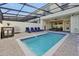 Private screened pool with lounge chairs and grill at 866 Paradise Dr, Davenport, FL 33897