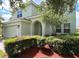 Two-story house with light green exterior, landscaping, and a two-car garage at 9026 Paolos Pl, Kissimmee, FL 34747