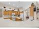 Open kitchen with island, white appliances and lots of wooden cabinetry at 1965 Fairway Loop, Kissimmee, FL 34746
