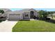 Single-story home with a two-car garage and well-manicured lawn at 27000 Nature View St, Leesburg, FL 34748