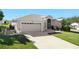 Single-story house with a two-car garage and neatly landscaped yard at 27000 Nature View St, Leesburg, FL 34748
