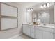 Double vanity bathroom with white cabinets and a large mirror at 3145 Emerald Acres Ln, Sanford, FL 32771