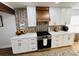 White kitchen cabinets, herringbone backsplash and a wooden range hood at 4143 Shadow Creek Cir, Oviedo, FL 32765