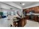Open kitchen with island, dark wood cabinets, and view into living room at 4685 Anson Ln, Orlando, FL 32814