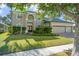 Two-story house with a three-car garage and lush landscaping at 5156 Tarragona Dr, Orlando, FL 32837