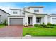 Two story home with a brick driveway and well-manicured lawn at 5282 Buttonsage Dr, Saint Cloud, FL 34772