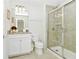Bathroom with granite countertop, white cabinets and a shower at 7212 Oakmoss Loop, Davenport, FL 33837