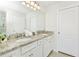 Bathroom with granite double vanity and white cabinets at 7212 Oakmoss Loop, Davenport, FL 33837