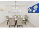 Elegant dining area features a marble table, six chairs, and stylish wall art at 7212 Oakmoss Loop, Davenport, FL 33837