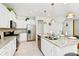 Modern kitchen with white cabinets, granite counters, and gold pendant lights at 7212 Oakmoss Loop, Davenport, FL 33837
