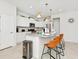 Modern kitchen with white cabinets, granite counters, and gold pendant lights at 7212 Oakmoss Loop, Davenport, FL 33837