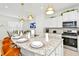 Modern kitchen features granite countertops, stainless steel appliances, and an eat-in island at 7212 Oakmoss Loop, Davenport, FL 33837