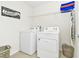 Bright laundry room with washer, dryer, and shelving at 7212 Oakmoss Loop, Davenport, FL 33837