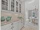 Butlers pantry with glass-front cabinets, granite countertop, and ample storage at 12023 Gold Creek Trl, Windermere, FL 34786