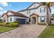 Two-story home with a gray facade, tile roof, and a paved driveway at 12023 Gold Creek Trl, Windermere, FL 34786