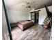 Main bedroom with sliding barn door to the bathroom and wood-look tile floors at 1230 Silverdale St, Deltona, FL 32725