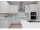 Modern white kitchen with stainless steel appliances and quartz countertops at 13333 Oakenshaw Ln, Orlando, FL 32832