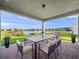 Covered patio with seating area, grill, and lake view at 13333 Oakenshaw Ln, Orlando, FL 32832