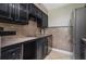 Galley kitchen with dark wood cabinets and stainless steel appliances at 5929 Windhover Dr # A02, Orlando, FL 32819