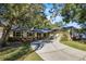 House exterior featuring a brick facade, green shutters, and a tree-lined driveway at 613 Banderas Ave, Ocoee, FL 34761