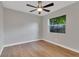 Spacious bedroom with wood-look floors, ceiling fan, and window with backyard view at 7023 Talbot Dr, Orlando, FL 32819