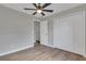Bright bedroom with wood-look floors, ceiling fan, and spacious closet at 7023 Talbot Dr, Orlando, FL 32819