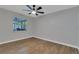 Bedroom with wood-look floors, ceiling fan, and window overlooking the pool at 7023 Talbot Dr, Orlando, FL 32819