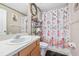 Bathroom with floral shower curtain and wood vanity at 705 Willow Run St, Minneola, FL 34715