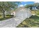 Tan single-story house with a two-car garage and spacious driveway at 705 Willow Run St, Minneola, FL 34715