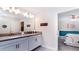 Double vanity bathroom with gray countertops and white cabinets at 8823 Interlocking Ct, Davenport, FL 33896
