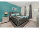 Guest bedroom with teal accent wall, gray bedding, and modern nightstands at 8823 Interlocking Ct, Davenport, FL 33896