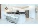 Modern kitchen with white cabinets, gray backsplash, and breakfast bar at 8823 Interlocking Ct, Davenport, FL 33896
