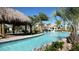 Resort-style pool with lazy river, palm trees, and thatched-roof cabana at 8823 Interlocking Ct, Davenport, FL 33896
