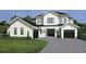 Two-story modern farmhouse with black accents, two-car garage, and landscaped lawn at 9136 Sheen Sound St, Orlando, FL 32836