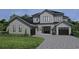 Two story home with gray siding, black roof and windows, and a paved driveway at 9136 Sheen Sound St, Orlando, FL 32836
